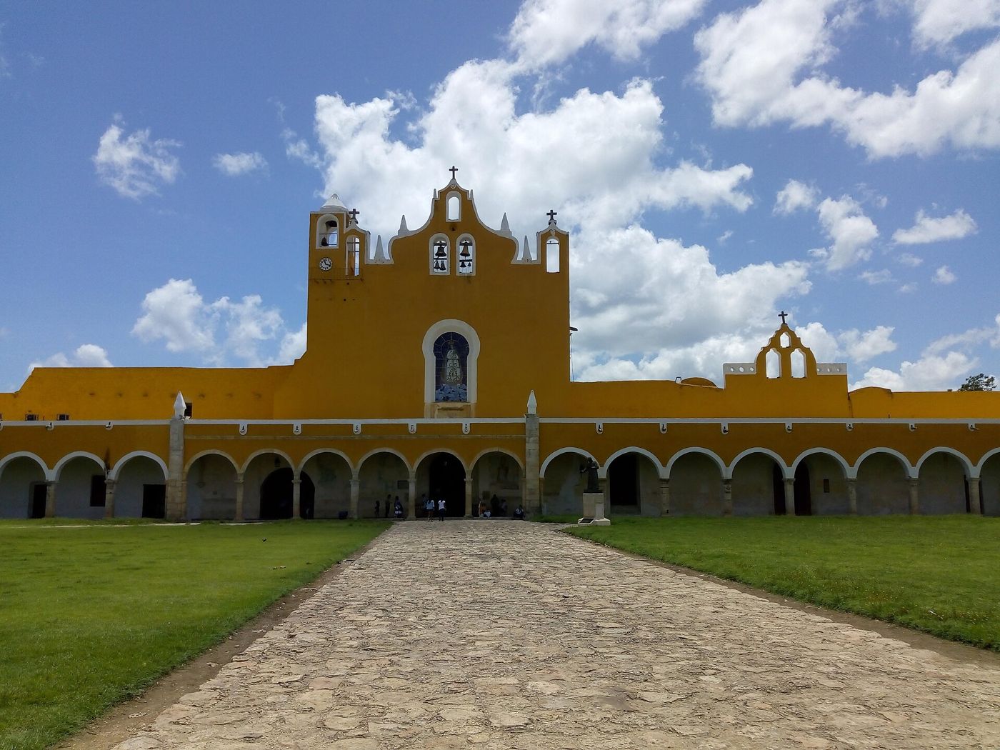 Yellow atrium of the Izamal convent under a blue dry-season sky