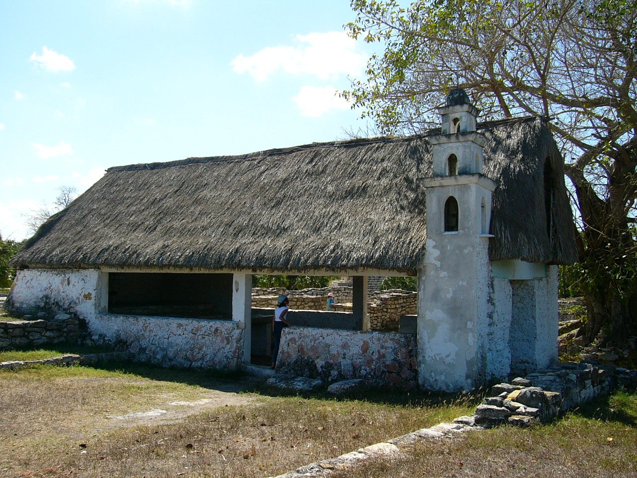 Small whitewashed chapel with a thatched roof built on top of a Maya platform at Xcambó
